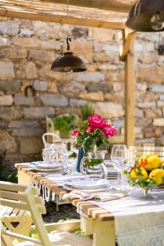 a table with plates and glasses and flowers on it at Bissantica, heritage and charm in rural Sardinia in Lunamatrona