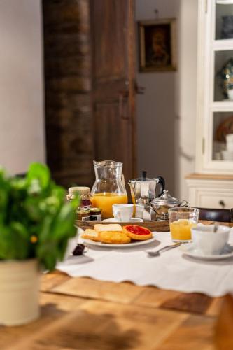 a table with a plate of food and orange juice at Bissantica, heritage and charm in rural Sardinia in Lunamatrona