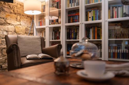 a library with a table with a chair and a book at Bissantica, heritage and charm in rural Sardinia in Lunamatrona