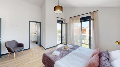 Nova VasにあるVilla Silviaのベッドルーム1室(ベッド1台、椅子、窓付)