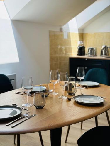 - une table en bois avec des verres à vin dans l'établissement Appartement Jules Ferry - centre, à Saumur