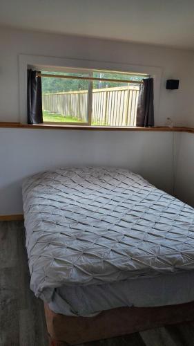 a bed in a room with a window and a bed sidx sidx sidx at Haven Touchstone in Roberts Creek