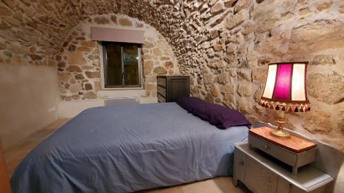 une chambre avec un lit dans un mur de pierre dans l'établissement Magnifique appartement, à Aregno