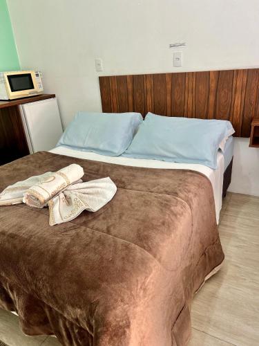 a bedroom with a bed with two towels on it at Suítes e PENHA-SC in Penha