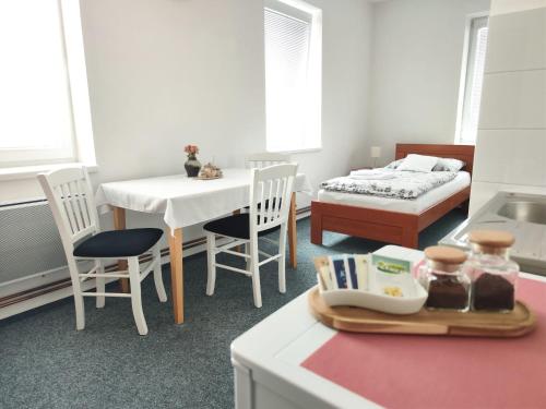 a kitchen with a table and chairs and a bed at Ubytování Goliáš in Krásná Lípa