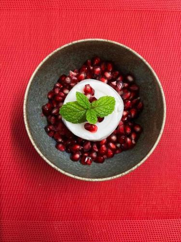 un bol rempli de grenades sur une table rouge dans l'établissement Isis et Horus ressourcement, à Scaër