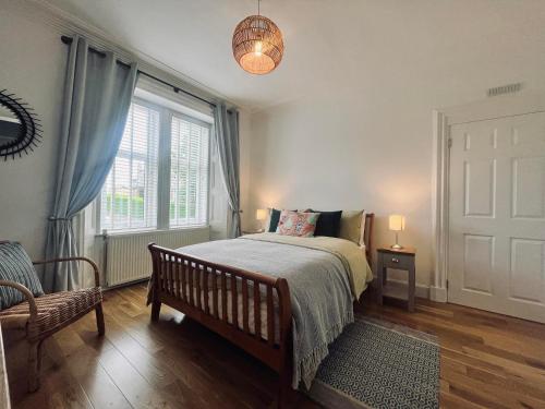a bedroom with a bed and a chair and a window at 7a Seatreat in Kinghorn
