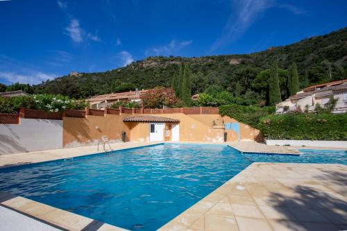 une piscine dans une villa avec une montagne en arrière-plan dans l'établissement Smartstay Sun - 100 m de la plage, au Lavandou