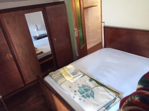 a small bedroom with a bed and a mirror at Maison de village avec jardin in Saint-Louis-et-Parahou