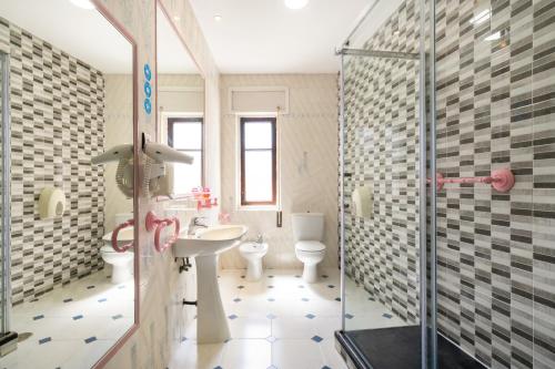 a bathroom with two toilets and a sink and a shower at Hotel La Quinta de Santillán in Chinchón