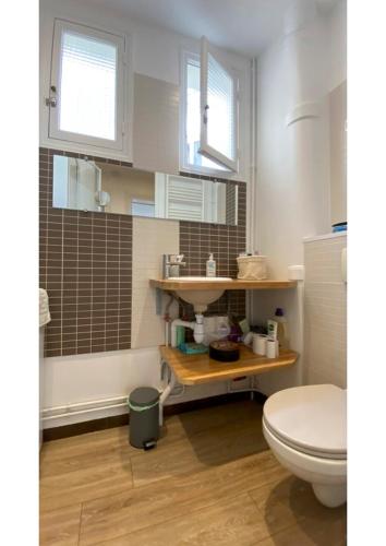 une salle de bain avec toilettes et lavabo dans l'établissement Sunny Bastille-Roquette Paris, à Paris