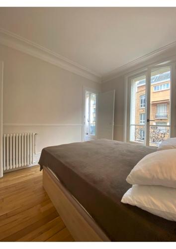 une chambre avec un grand lit et une fenêtre dans l'établissement Sunny Bastille-Roquette Paris, à Paris