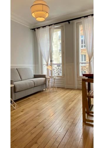 un salon avec un canapé et une table dans l'établissement Sunny Bastille-Roquette Paris, à Paris
