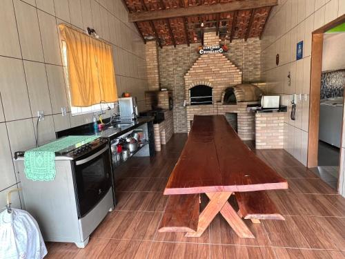 a large kitchen with a wooden table in a room at Chácara Deus Proverá in Socorro