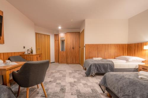 a hotel room with two beds and a desk at Willa Marti GOLD in Zakopane