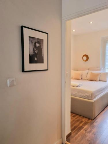 une chambre avec un lit avec un tableau sur le mur dans l'établissement Appartement de charme dans les Batignolles, à Paris