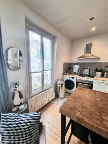 - une cuisine avec une table en bois dans une chambre dans l'établissement Appartement de charme dans les Batignolles, à Paris