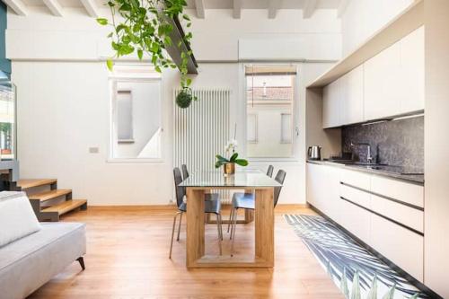 a kitchen with a table and chairs in a room at Domus: modern Loft in the center of Parma in Parma
