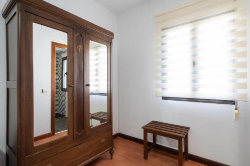 a mirror and a wooden dresser in a room at Hotel La Quinta de Santillán in Chinchón