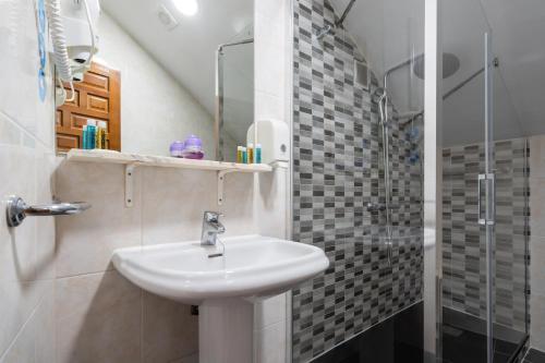 a bathroom with a sink and a shower at Hotel La Quinta de Santillán in Chinchón