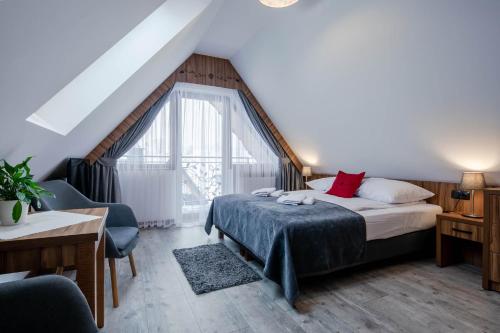a bedroom with a bed and a large window at Willa Marti GOLD in Zakopane