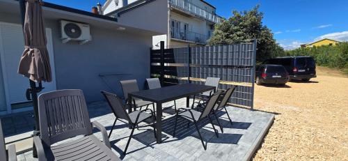 a table and chairs on a patio with a fence at Panorama Apartments in Povljana