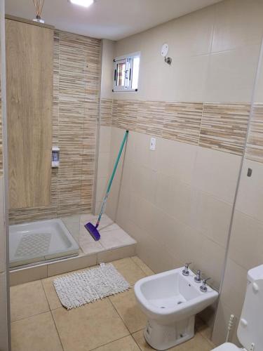 a bathroom with a tub and a toilet and a mop at la florida C in Salta
