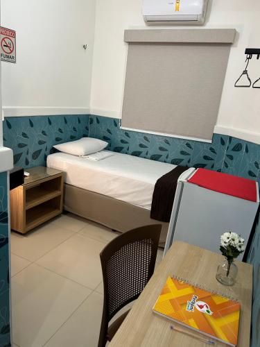 a small room with a bed and a table at Mais Hotel Express in São Luís