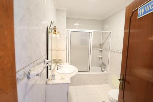 a bathroom with a sink and a shower and a toilet at Casa da Audiência Lote 32 in Monte Gordo