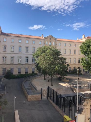 un grand bâtiment avec une cour en face dans l'établissement Loft lumineux et coloré en plein centre, à Marseille