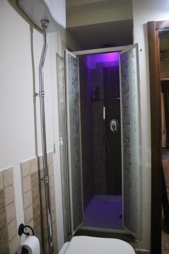 una doccia con illuminazione viola in un bagno di Gate 295 a Livorno