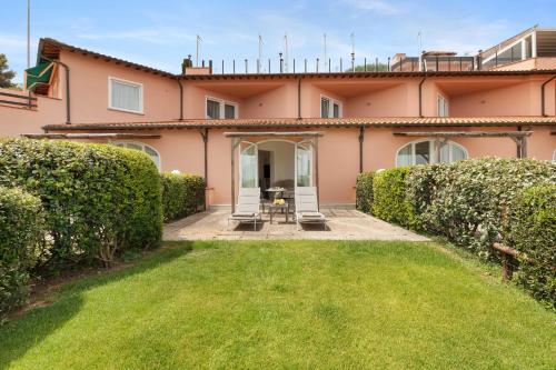 an exterior view of a pink house with a yard at Hotel Villa Domizia in Porto Santo Stefano