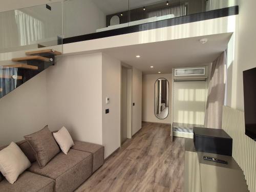 a living room with a couch and a staircase at Meraviglia Boutique Hotel in Sarandë