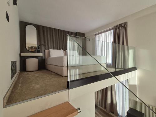 a glass staircase in a room with a couch at Meraviglia Boutique Hotel in Sarandë