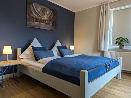 a bedroom with a large bed with blue sheets at Ferienwohnung Coburg, familienfreundlich und stilvoll in Coburg