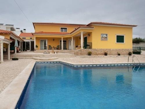 a house with a swimming pool in front of it at Porto Dinheiro Beach I in Lourinhã