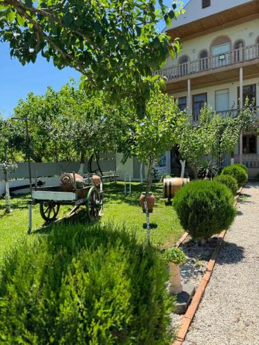a garden with an old tractor in front of a building at Didvela Villa in Kutaisi