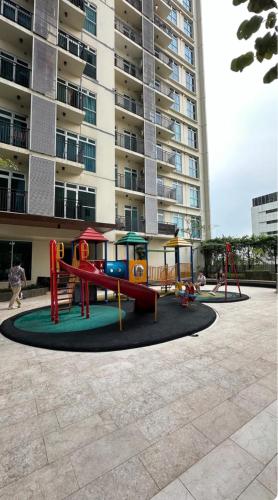 a playground in front of a tall apartment building at Apt Puri Orchard at puri in Jakarta