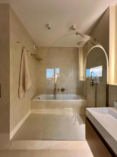 une salle de bain avec une baignoire et un lavabo dans l'établissement Duplex vue Montmartre lumineux et design épuré, à Saint-Ouen