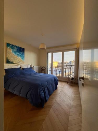 une chambre avec un lit et une grande fenêtre dans l'établissement Duplex vue Montmartre lumineux et design épuré, à Saint-Ouen