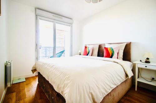 une chambre blanche avec un grand lit et une fenêtre dans l'établissement Luxury 2 rooms Apartment with balcony, à Puteaux