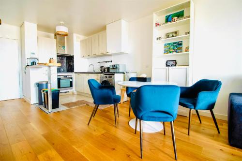 une cuisine et une salle à manger avec une table et des chaises dans l'établissement Luxury 2 rooms Apartment with balcony, à Puteaux