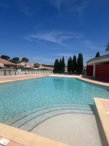 une grande piscine avec de l'eau bleue dans l'établissement Maison proche de la plage, à Vic-la-Gardiole