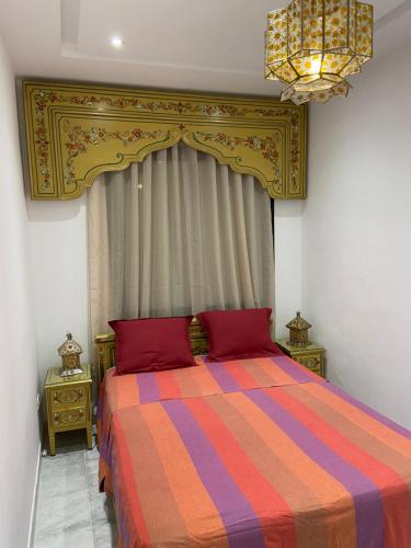 a bedroom with a bed with a colorful striped comforter at Marsa - Sidi Bousaid Lovely Authentic Apartment in La Marsa