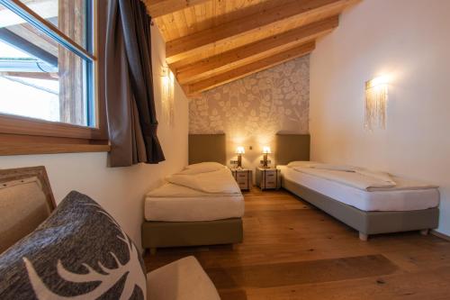 a bedroom with two beds and a window at Mountainlodge Luxalpine in San Vigilio Di Marebbe