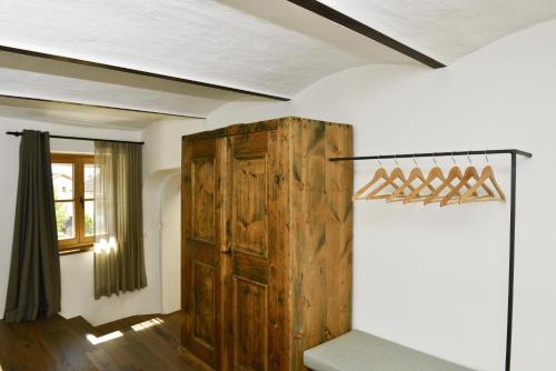 a room with a wooden cabinet and a window at Apartments Mitterhof 1544 in Brunico