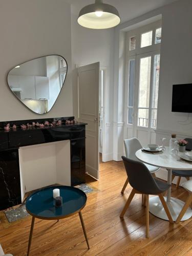 - un salon avec une table et un miroir dans l'établissement Le Toulousain 101 - Appartement Calme en Hypercentre - Quartier Jeanne d'Arc, à Toulouse