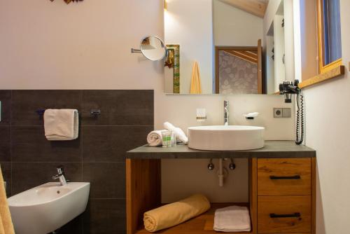 a bathroom with a sink and a toilet and a tub at Mountainlodge Luxalpine in San Vigilio Di Marebbe