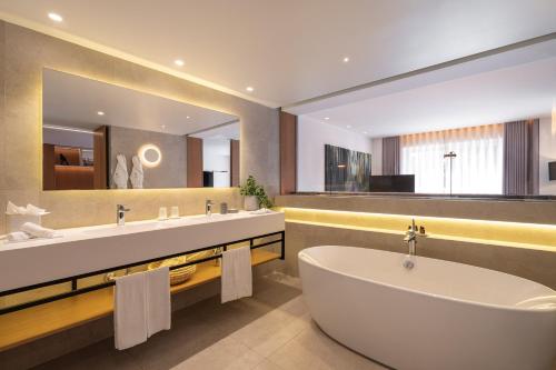a bathroom with two sinks and a tub and a mirror at Onyria Quinta da Marinha Hotel in Cascais