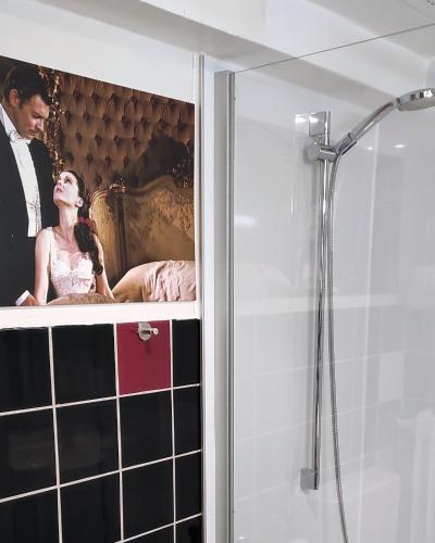 a bathroom with a picture of a bride and groom at Retro - Art - Hotel Lünen in Lünen